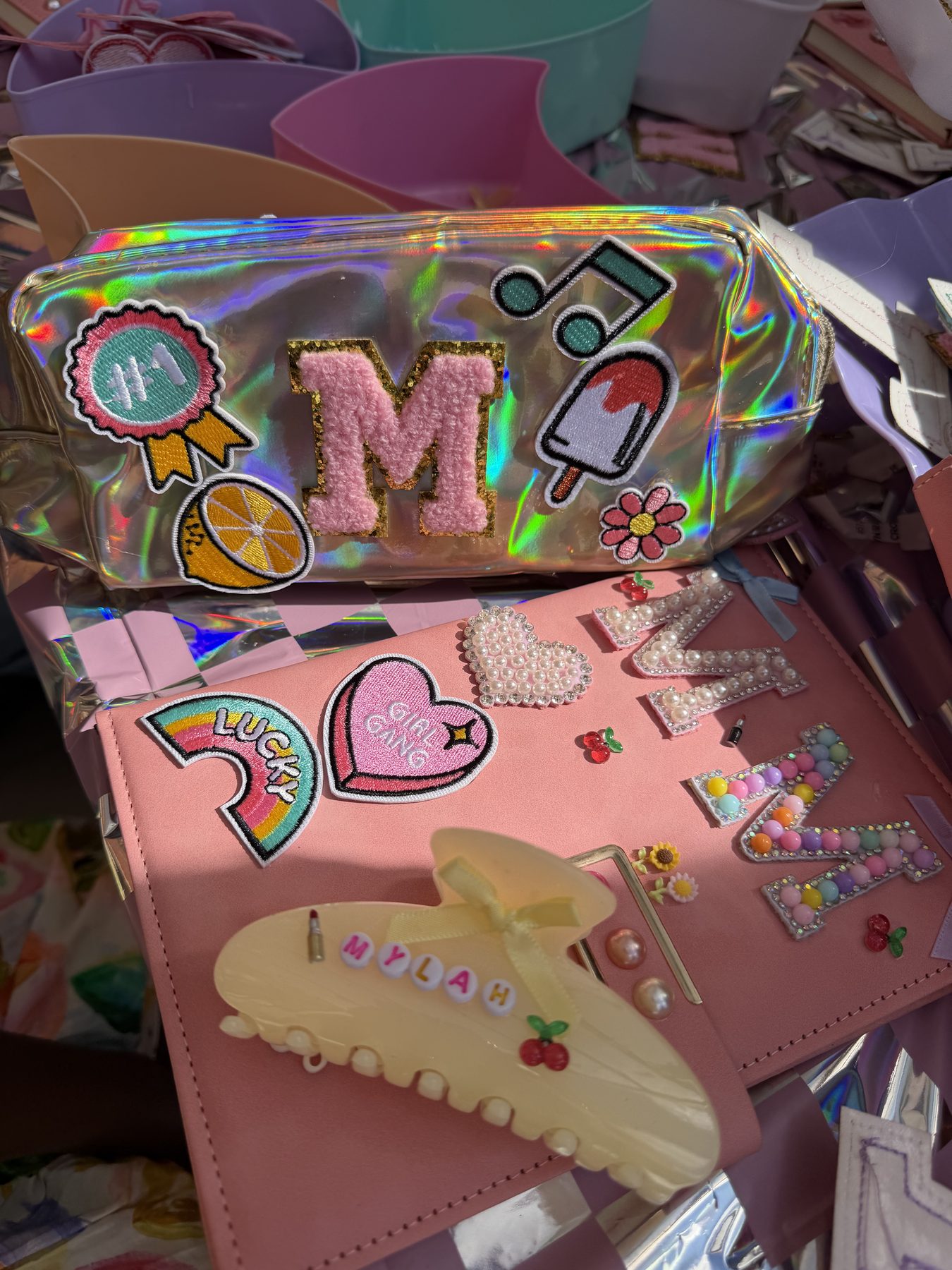 Holographic pencil case customised with embroidered letter patches at a craft party