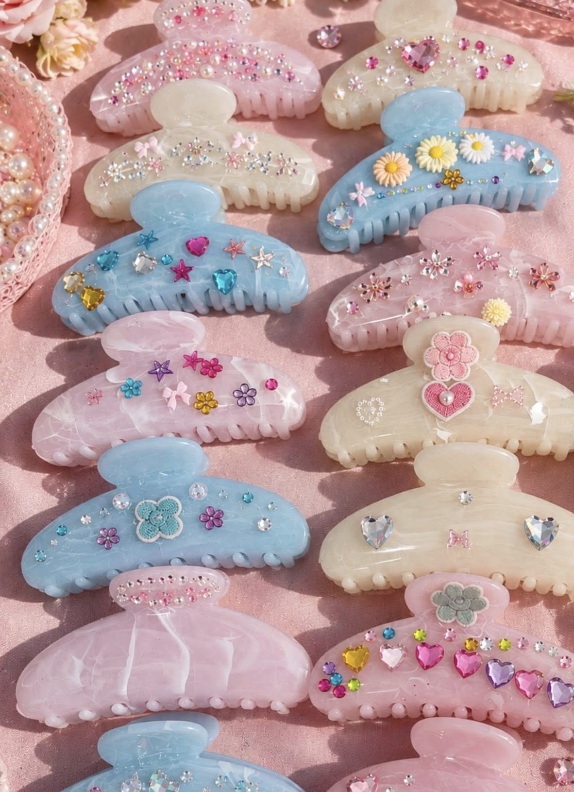 Pastel hair claw clips decorated with gems, daisies and hearts at a craft party